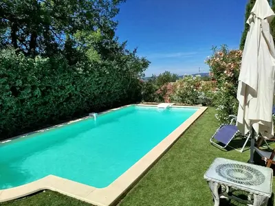 a swimming pool in a yard with an umbrella at Roussillon in Roussillon