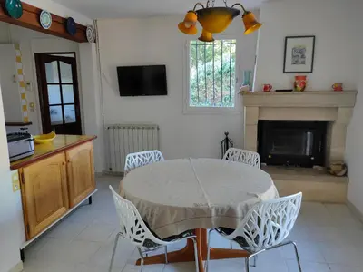 a living room with a table and chairs and a fireplace at Roussillon in Roussillon