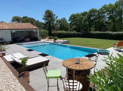 a swimming pool with a table and chairs next to it at Charmant Appartement au calme avec piscine au pied du Ventoux en Provence in Carpentras