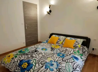 a bedroom with a bed with a floral bedspread and yellow pillows at BOHO 2 Vue Panoramique in Bonnieux