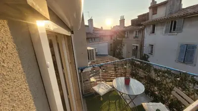 a balcony with a table and a view of a building at Appartement duplex sur les toits d'Aix avec terrasse ensoleillée in Aix-en-Provence