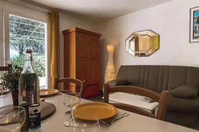 a living room with a table with a bottle of wine at Maison en Provence - Les Bastidons du Ventoux in Aubignan