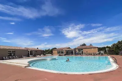 a person in a swimming pool at a resort at Maison en Provence - Les Bastidons du Ventoux in Aubignan