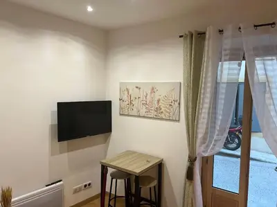 a room with a tv and a table and a stool at 4M Studio in Jouques