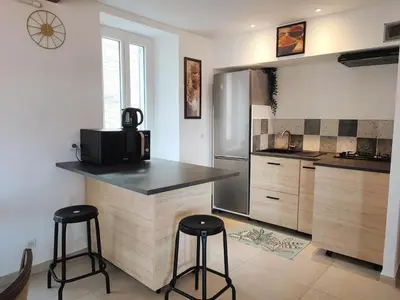 a kitchen with a counter and two bar stools at BOHO 1 Vue Exceptionnelle in Bonnieux