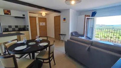 a living room with a table and a couch at BOHO 1 Vue Exceptionnelle in Bonnieux