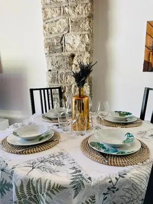 a table with plates and glasses and a vase at Maison Campagne Aixoise in Éguilles