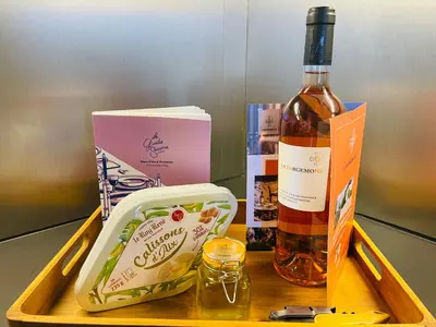 a bottle of wine and a box on a wooden tray at Maison Campagne Aixoise in Éguilles