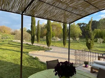 a patio with a table and a view of a park at Maison Campagne Aixoise in Éguilles