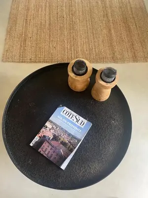 a table with a book and two wooden objects on it at Le Verger in Aix-en-Provence