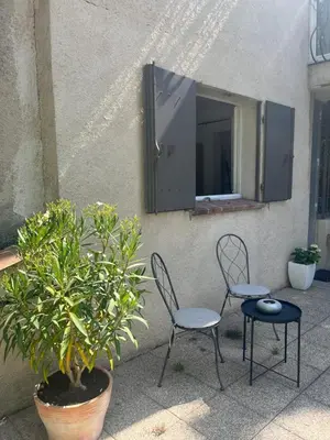 two chairs and a mirror on the side of a building at Le Verger in Aix-en-Provence
