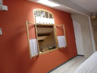 a mirror in a room with a orange wall at Mas Seraphin in LʼIsle-sur-la-Sorgue