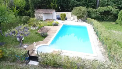 a large swimming pool in a yard with a house at Mas Seraphin in LʼIsle-sur-la-Sorgue