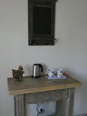 a wooden table with two cups and a tea kettle at Mas Seraphin in LʼIsle-sur-la-Sorgue