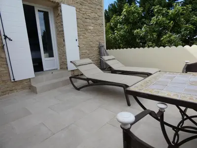 a patio with two chairs and a table at Mas Seraphin in LʼIsle-sur-la-Sorgue