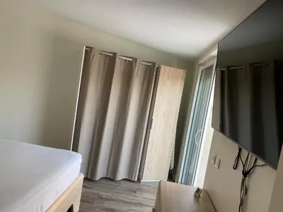 a bedroom with a bed and a flat screen tv at Petit paradis en Provence in Velleron