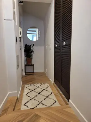 a hallway with a door and a rug at Appartement des Augustins in Aix-en-Provence