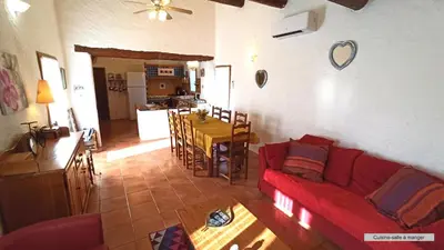 a living room with a red couch and a table at La Bastide de la Peyrolière avec piscine et tennis face au Luberon in Apt