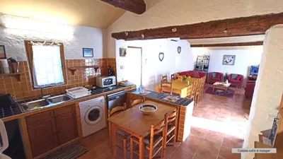 a kitchen and living room with a table and a sink at La Bastide de la Peyrolière avec piscine et tennis face au Luberon in Apt