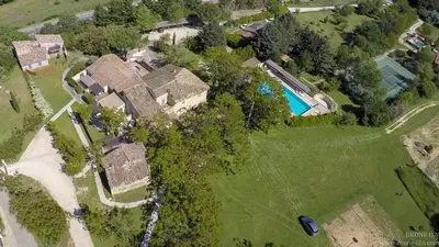 an aerial view of a house with a swimming pool at La Bastide de la Peyrolière avec piscine et tennis face au Luberon in Apt
