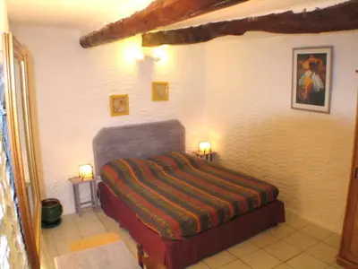 a bedroom with a bed and two lamps on tables at La Bastide de la Peyrolière avec piscine et tennis face au Luberon in Apt