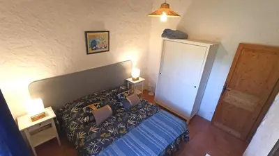 a bedroom with a bed with a blue comforter at La Bastide de la Peyrolière avec piscine et tennis face au Luberon in Apt