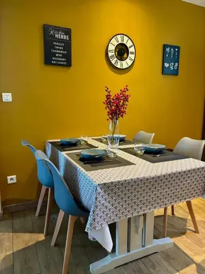 a living room with a flat screen tv and a table at Appartement spacieux et charmant in Caumont-sur-Durance