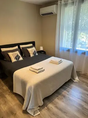 a bedroom with a bed with white sheets and a window at Ar de Vie villa chaleureuse en Provence in Ventabren