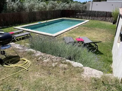 a swimming pool in a yard with a table and a grill at Ar de Vie villa chaleureuse en Provence in Ventabren