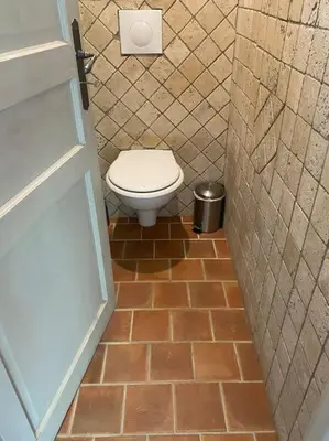 a bathroom with a toilet and a tiled floor at Ar de Vie villa chaleureuse en Provence in Ventabren