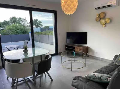 a living room with a table and a couch at Logement Le Puy Sainte Réparade in Le Puy-Sainte-Réparade