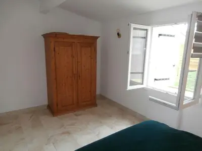 a room with a wooden cabinet and a window at gîte à Caromb ( Mt Ventoux ) in Caromb