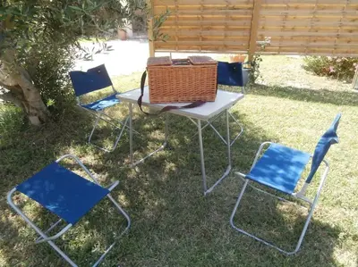 a picnic table and four chairs in the grass at gîte à Caromb ( Mt Ventoux ) in Caromb