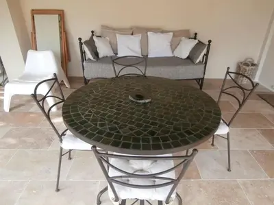 a table and chairs in a living room with a couch at gîte à Caromb ( Mt Ventoux ) in Caromb
