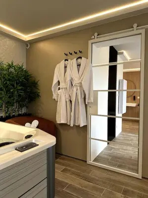 a bathroom with a mirror and a robe hanging on a wall at BDSM TanTra Love Room & SPA in Miramas