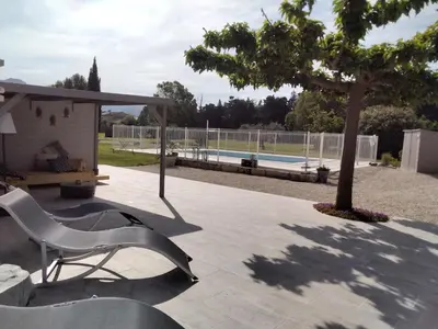 a white chair sitting on a patio next to a tree at MAS LAURIE in Cheval-Blanc
