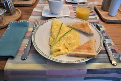 a plate of food with eggs and toast on a table at Ici et Là - Chambres d'hôtes in Velleron