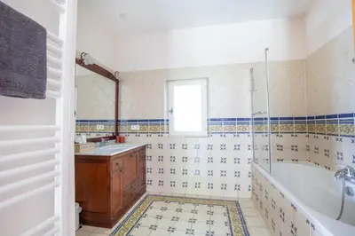 a bathroom with a tub and a sink at Mas provençal 14 personnes - parking privé in Le Thor
