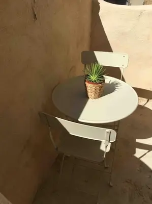 a white table and a chair with a plant on it at Magnifique studio indépendant 35m2 proche du lac et au coeur du village in Peyrolles-en-Provence