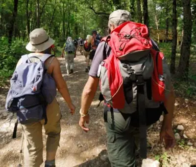 a group of people walking down a trail with backpacks at Magnifique studio indépendant 35m2 proche du lac et au coeur du village in Peyrolles-en-Provence