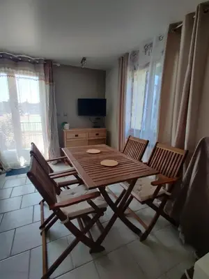 a wooden table and chairs in a living room at STUDIO DU CHARME PROVENCAL in Sénas