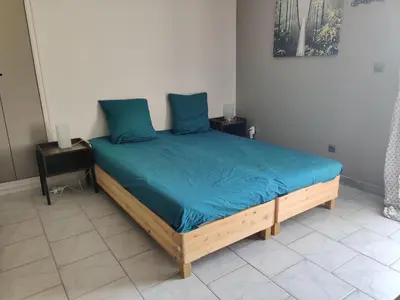 a bedroom with a bed with blue sheets and pillows at STUDIO DU CHARME PROVENCAL in Sénas
