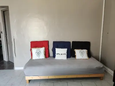a bed with four pillows on it in a room at STUDIO DU CHARME PROVENCAL in Sénas