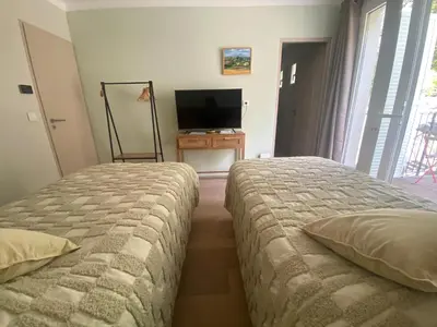 two beds in a room with a tv and a bedroom at Le Repos du Keyrié in Saint-Marc-Jaumegarde