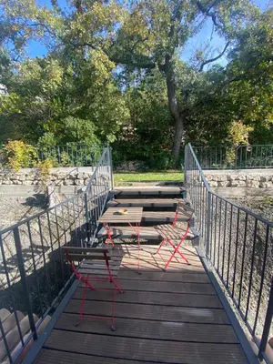 two chairs and a table on a wooden bridge at Le Repos du Keyrié in Saint-Marc-Jaumegarde