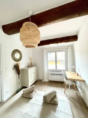 a living room with a table and a window at Ravissant appartement au cœur d’Aix in Aix-en-Provence