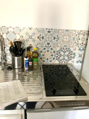 a kitchen counter with a sink and a stove top at Logement neuf, tout confort, au coeur du village in Saint-Didier