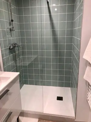 a shower with a glass door in a bathroom at Logement neuf, tout confort, au coeur du village in Saint-Didier