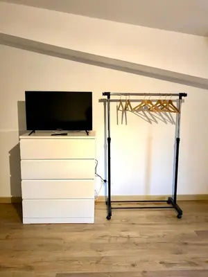 a tv on a dresser in a room at Logement neuf et climatisé, au coeur du village in Saint-Didier