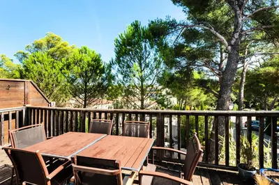 a wooden table and chairs on a deck at Les Coteaux de Pont Royal en Provence - maeva Home - Maison chaleureuse climatisée 4 pièces 6 personnes - Prestige - super Home MAE-2304 in Mallemort